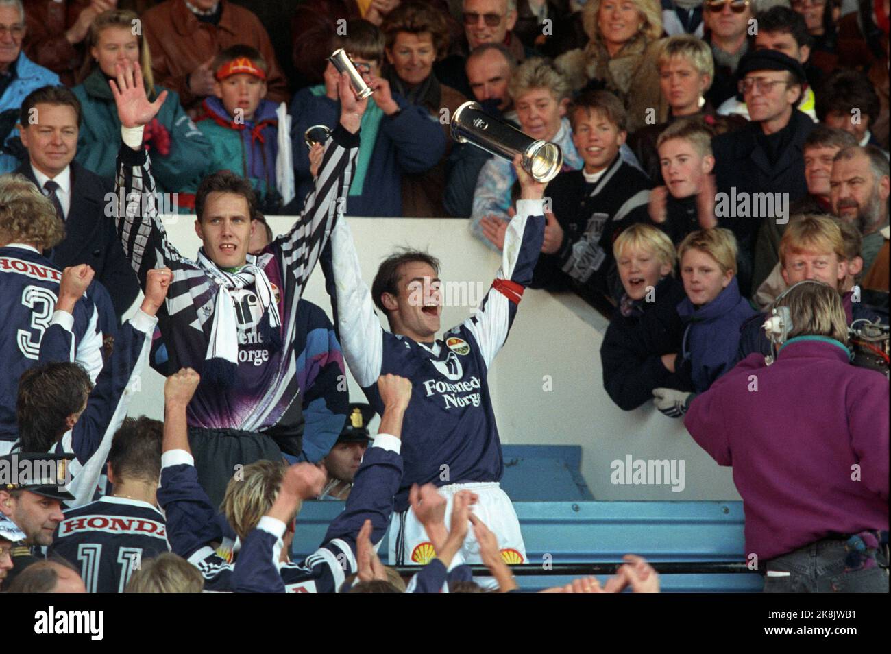 Oslo 19911020: Cup final 1991. Rosenborg (RBK) - Strømsgodset (SIF) (2-3). Ullevaal Stadium. Picture: Strømsgodset players receive trophies and rejoice over the cup victory. Here keeper Frode Olsen (t.v.) and team captain Halvor Storskogen with trophies and royal trophies. Photo: Morten Holm Stock Photo