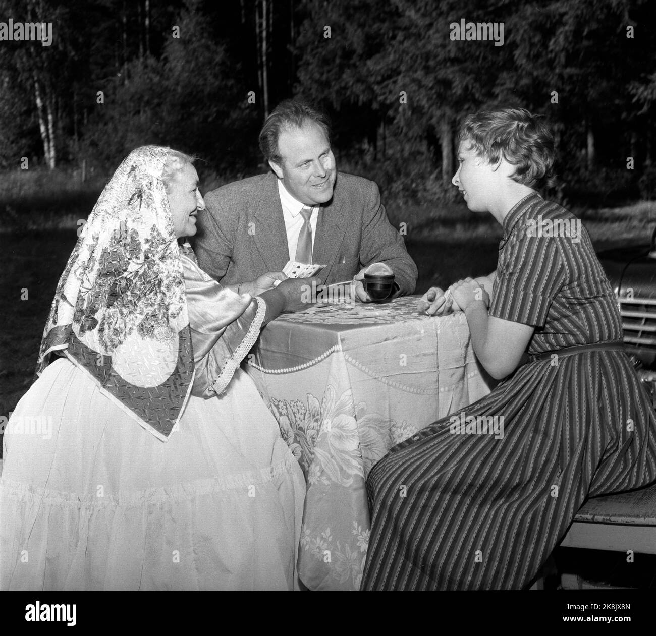 Hokksund 19590709 Norwegian National Broadcasting NRK at work in the field. Here, reporter Odd Nordland has got two gypsy women / two women from the space people in a camp in Hokksund to predict him in cards. Photo: Knoblauch / NTB / NTB Stock Photo