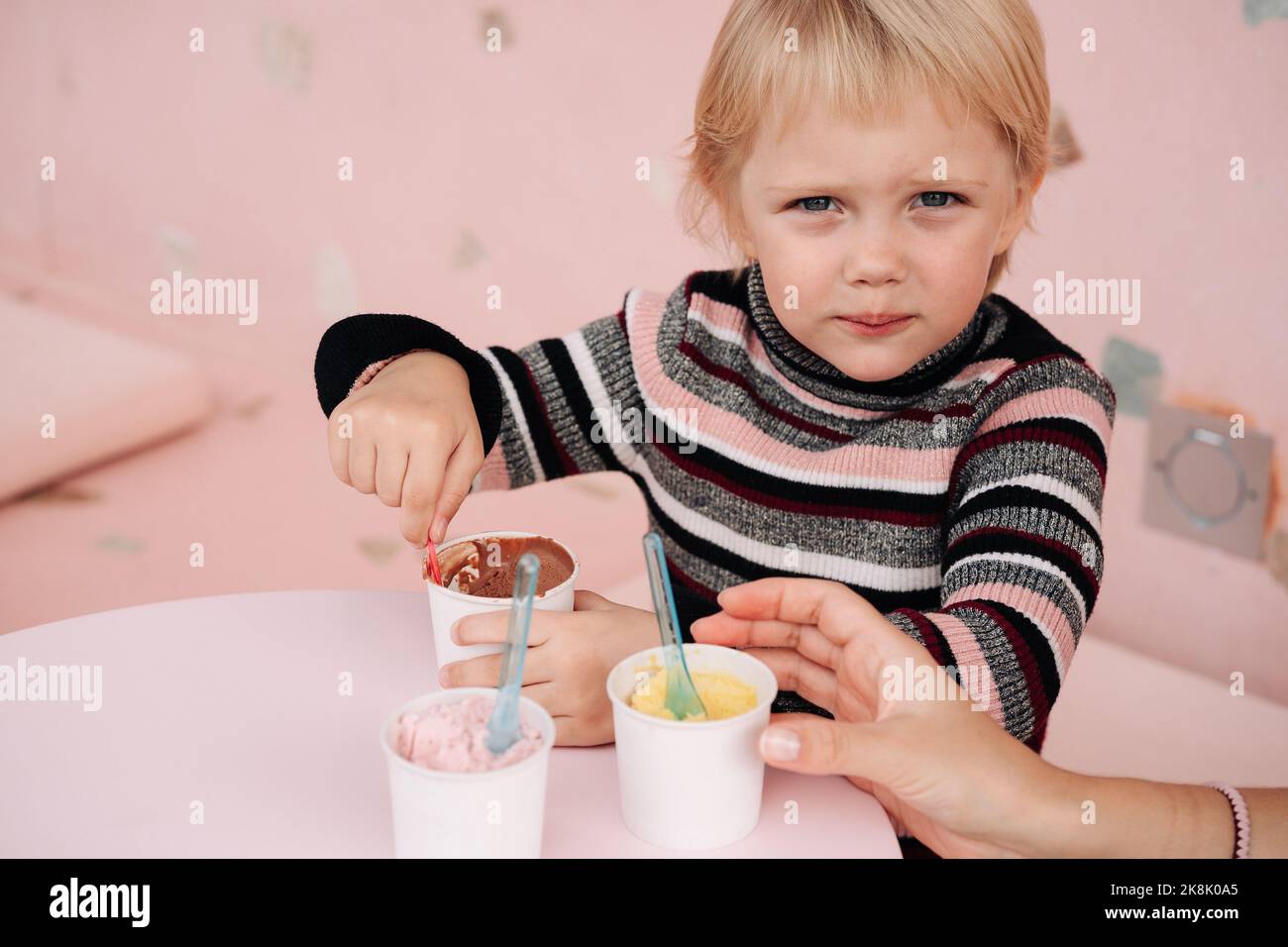 Child eating ice cream in a cafe. Set of bowls with various Ice Cream