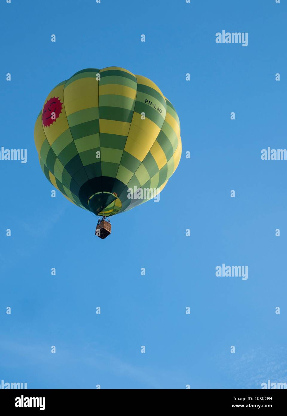 Sint Niklaas, Belgium, September 04, 2022, Beautiful hot air balloon with different colors yellow and green high in the sky Stock Photo