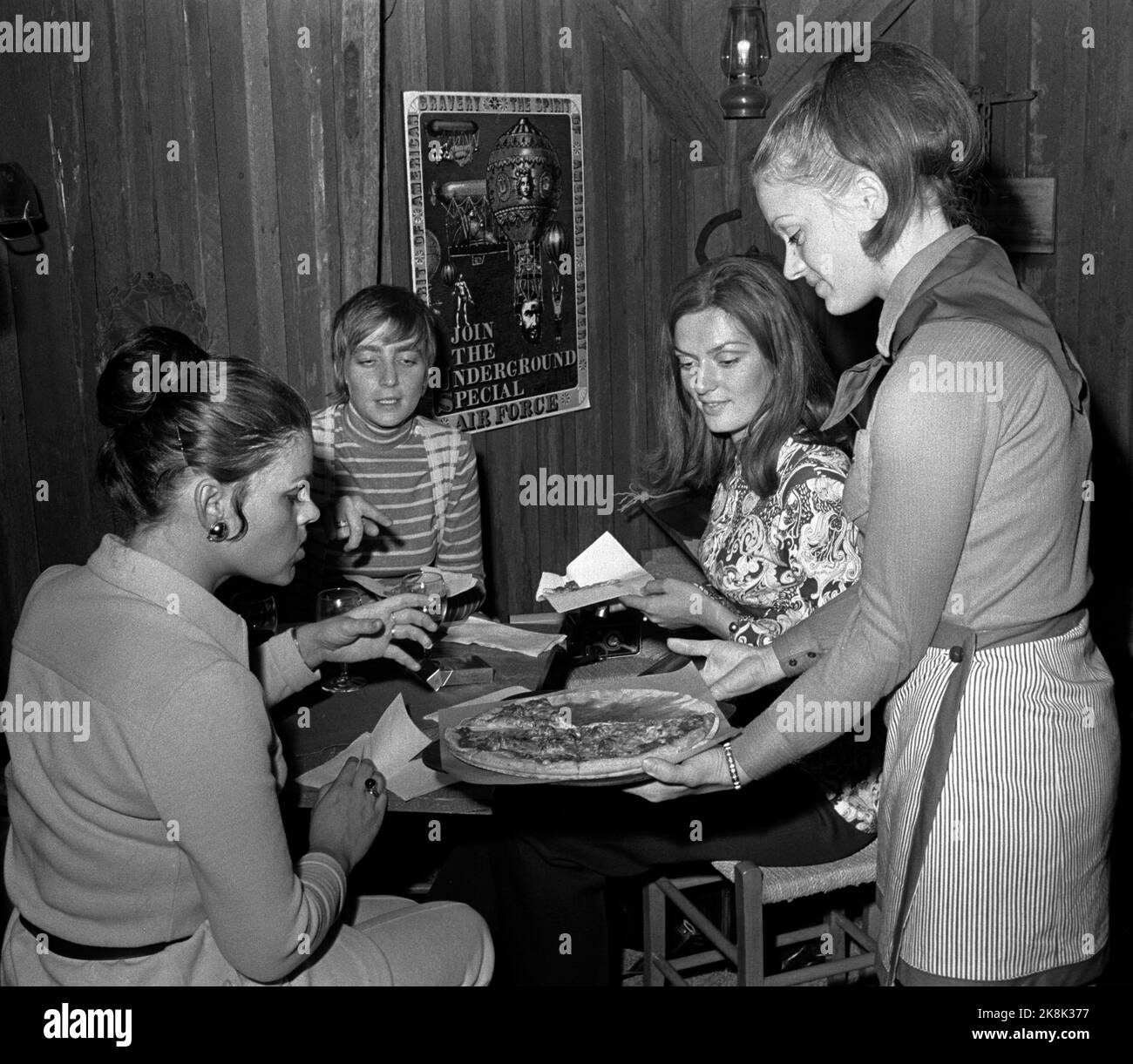 Oslo 19700525 Pizza restaurant in the index house. Female waiter serves pizza to three ladies around a table in the restaurant. Photo: NTB / NTB Stock Photo