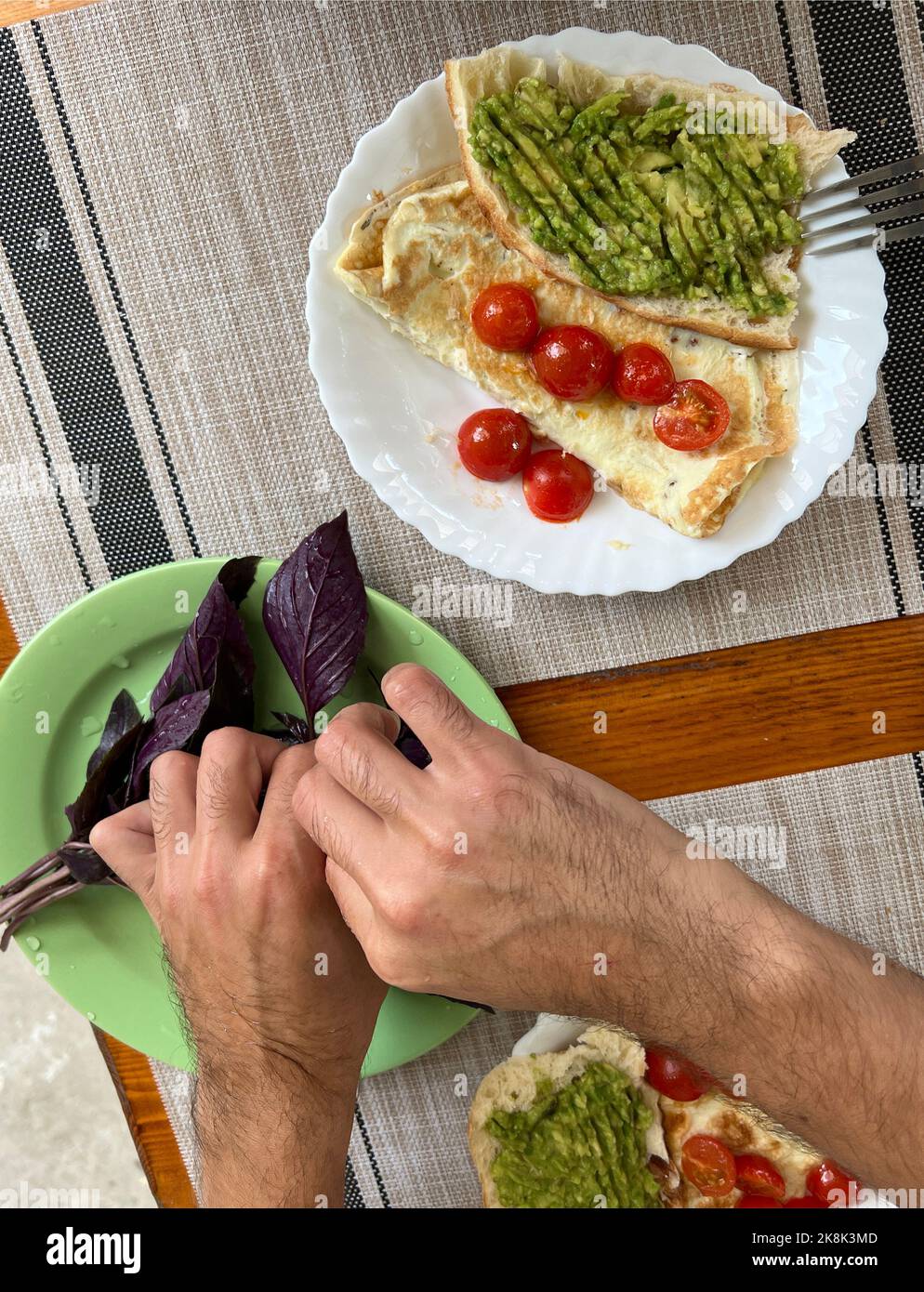 Fried omelette with tomatoes, onion and herbs. Delicious breakfast with eggs and toasts. Stock Photo