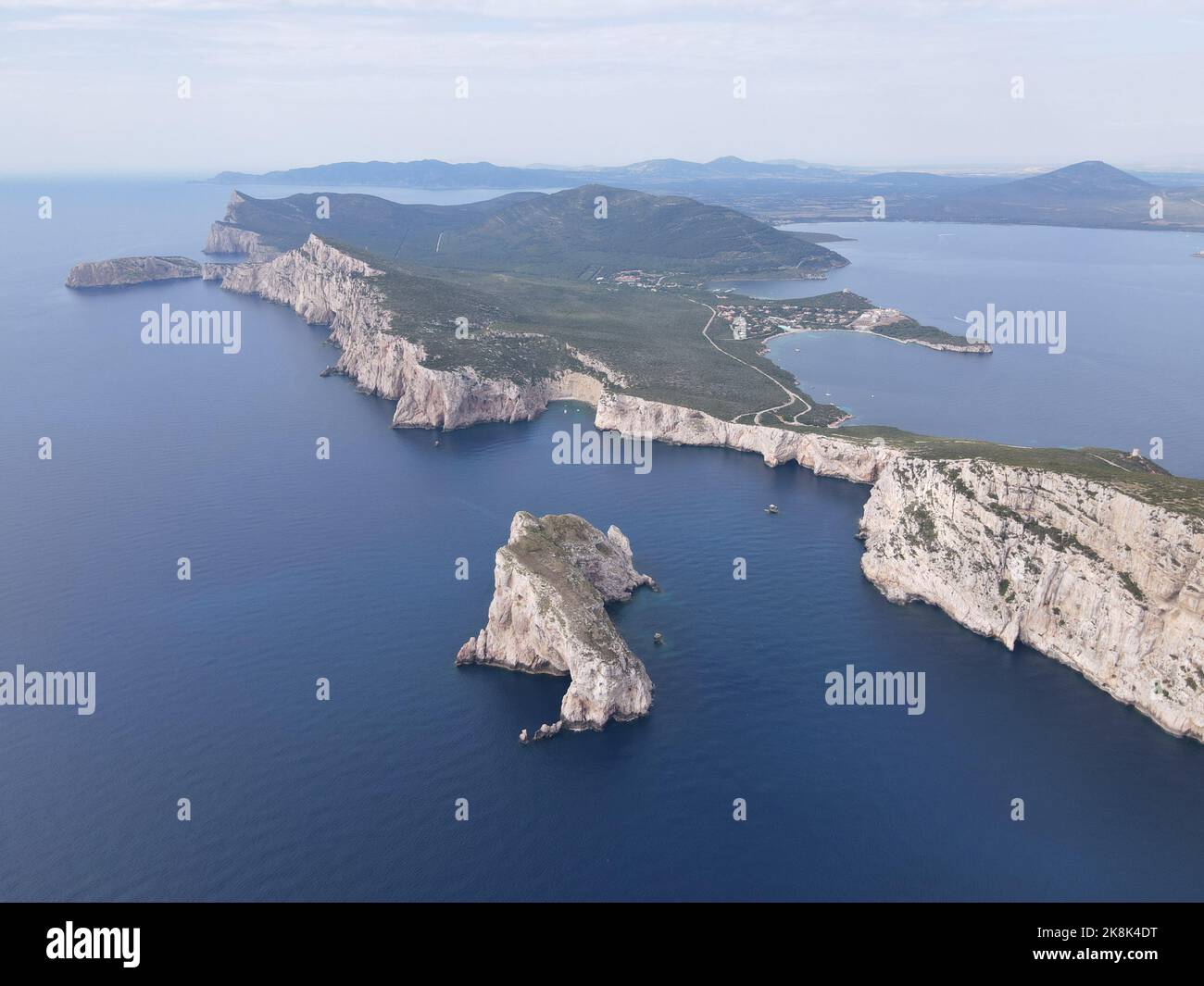 An aerial view of Capo Caccia's vertical cliffs surrounded by the clear ...