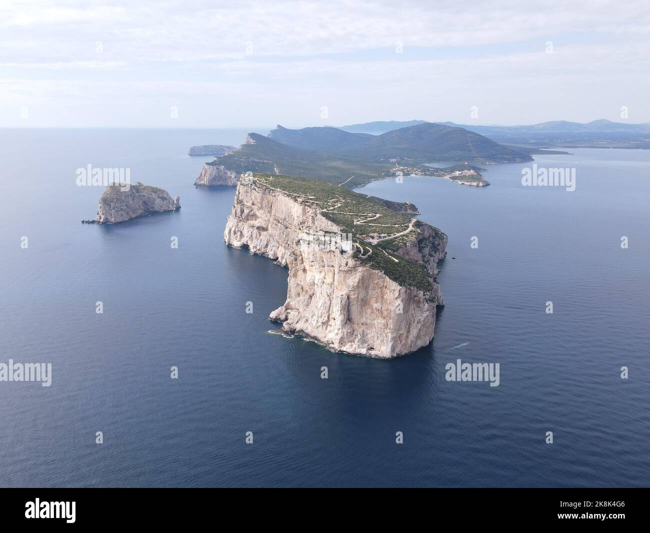 An aerial view of Capo Caccia's vertical cliffs surrounded by the clear ...
