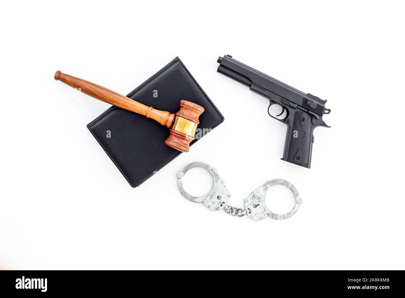 Hand gun weapon with handcuffs illegal use of weapons concept Stock