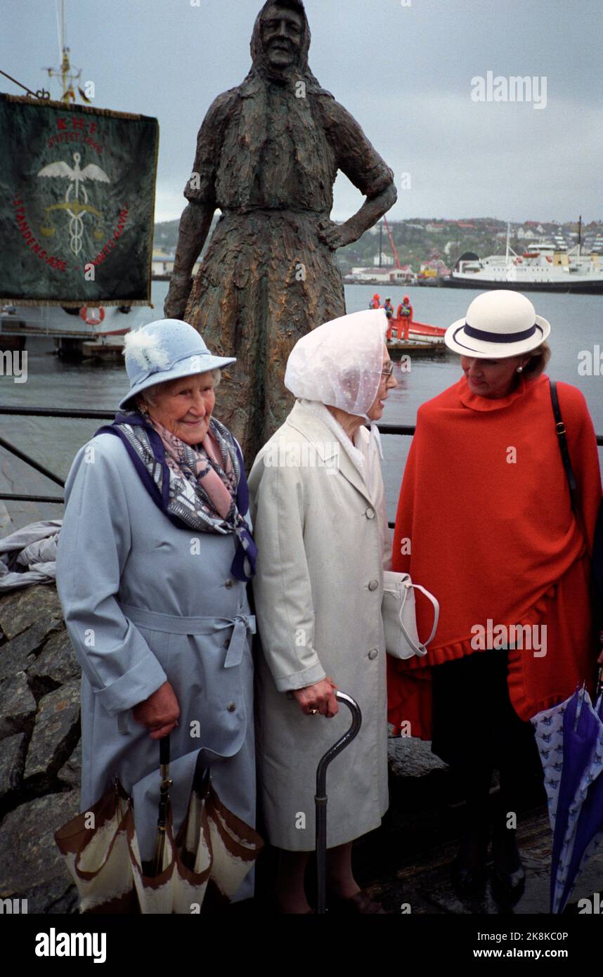 Kristiansund June 29, 1992. King Harald and Queen Sonja at the sculpture 'Klippfiskkjerringa' that Queen Sonja has just unveiled. She is in conversation with two of the clipfish, Signy Tønnesen and Jenny Hval who together with Magnora Schnell everyone got to greet the royal couple. King Harald and Queen Sonja visit Kristiansund on the occasion of the city's 250th anniversary.  Photo; Kjell HERSKEDAL / NTB / NTB Stock Photo