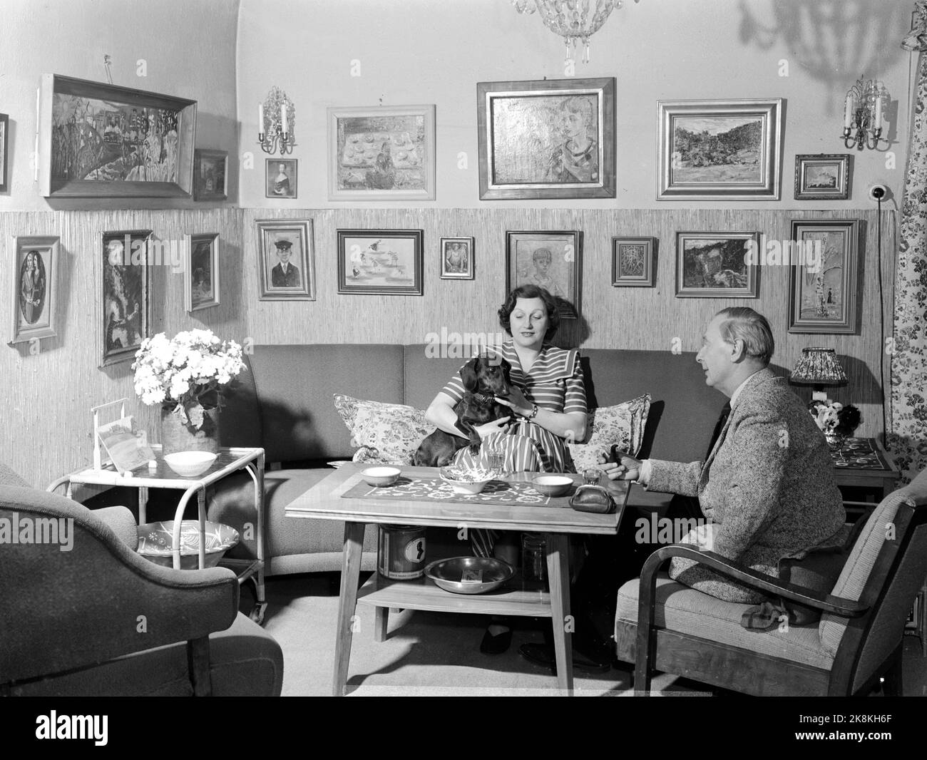 Oslo 195012. The artist Per Krohg has been given the honorable assignment to take care of the interior and artistic design of the security council's meeting room in the UN. The Ministry of Foreign Affairs has allocated money for the work that is a gift from Norway. Kristian Krohg with his wife Ragnhild and the dog Selsom at home in the living room. Photo: Current / NTB Stock Photo