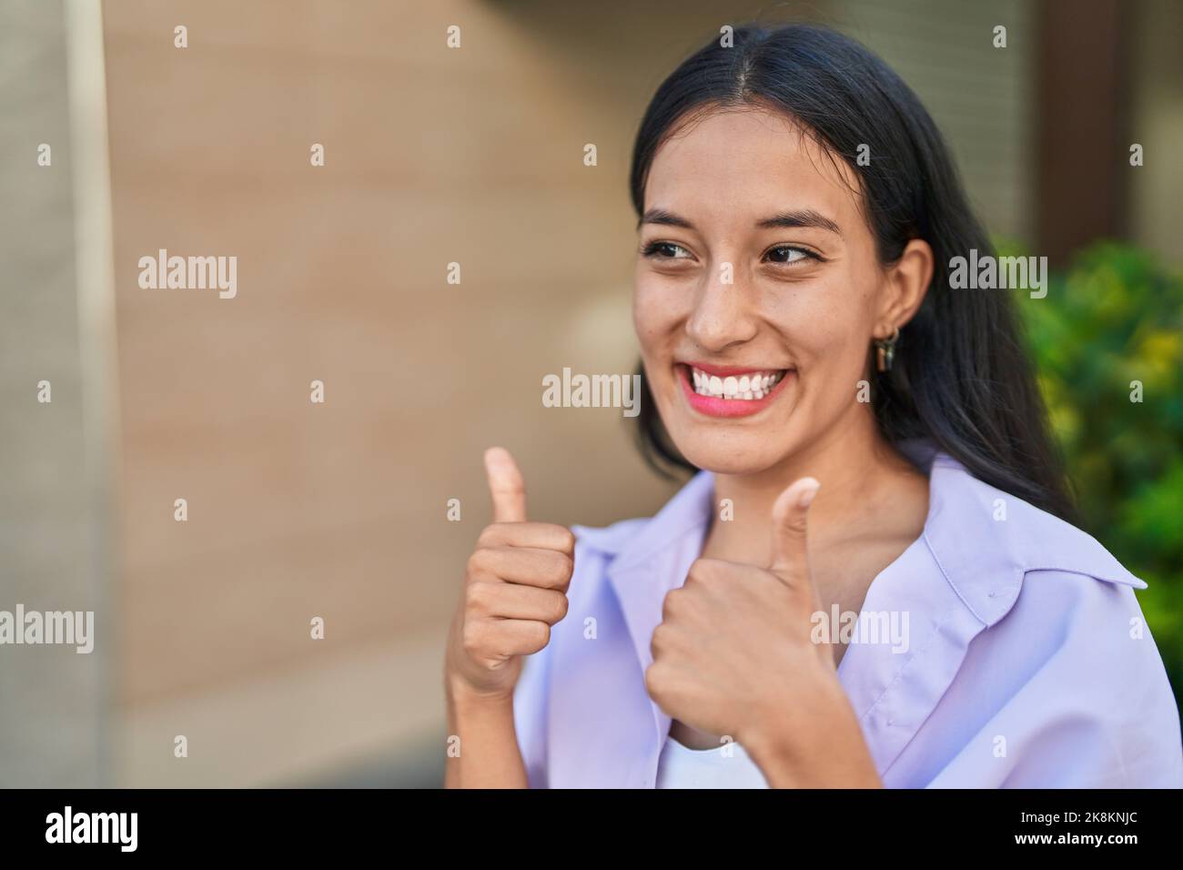 Young beautiful hispanic woman smiling confident doing ok sign with ...