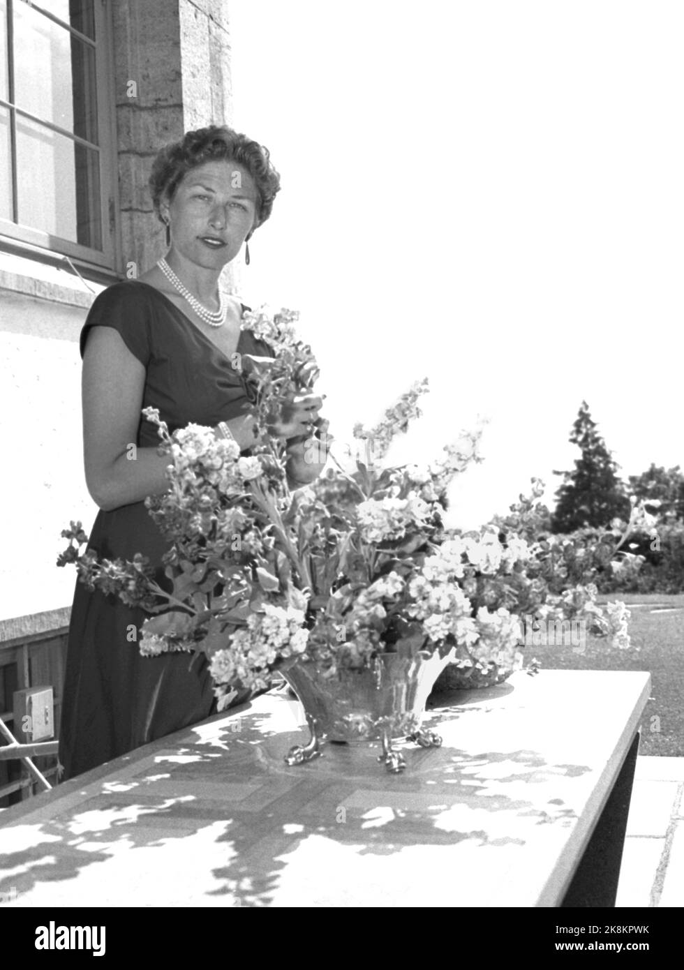 Skaugum 19560707. Princess Astrid the country's first lady at Skaugum. The princess has taken over a good part of the royal house's official representation duties after her mother Crown Princess Märtha died. Her big hobbies are gardening and ceramic work. Here, Princess Astrid decorates with flowers. Pearl chain. Photo: Sverre A. Børretsen / Aage Storløkken / Current / NTB Stock Photo