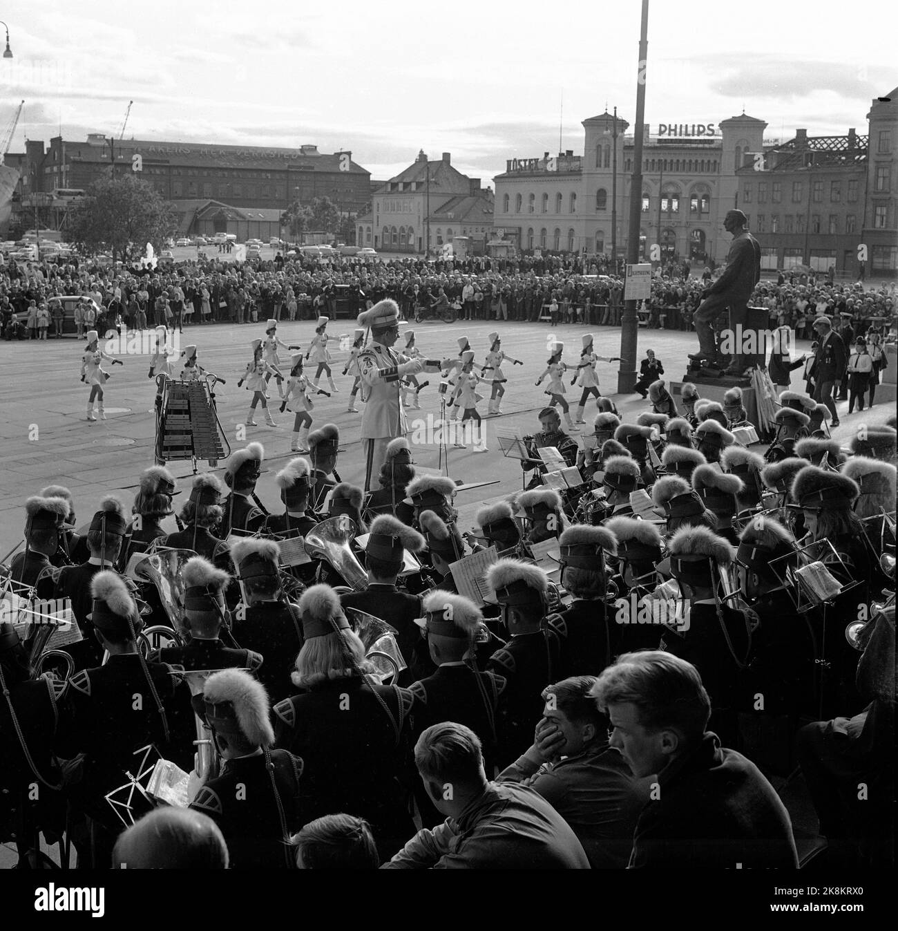 Oslo 19650701 Bispehaugen School Music Corps from Trondheim on tour in Oslo, Bispehaugen was one of the corps in Norway that used shows, drill, singing and dancing at their concerts, and the corps received a lot of attention when they represented Norway abroad. Here from the corps' concert at City Hall Square, led by its dynamic conductor music fenrik Rolf A. Stokke, and with the show of Bispehaugen's 16 flag-drill girls with impeccable precision in the background. Photo: Laurvik / NTB / NTB Stock Photo