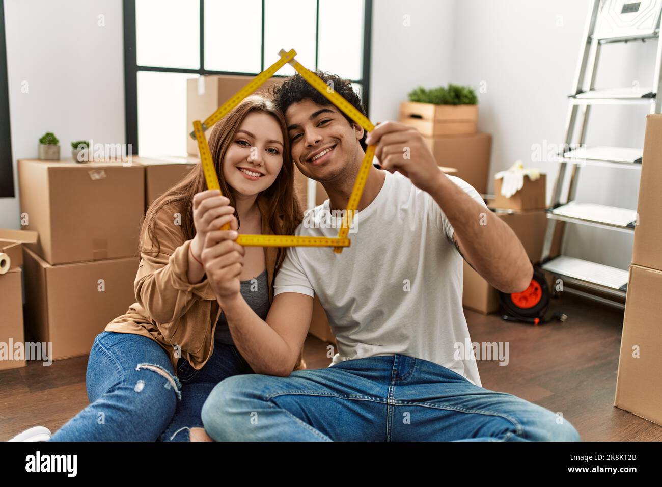 Young couple smiling happy holding house project at new home Stock ...