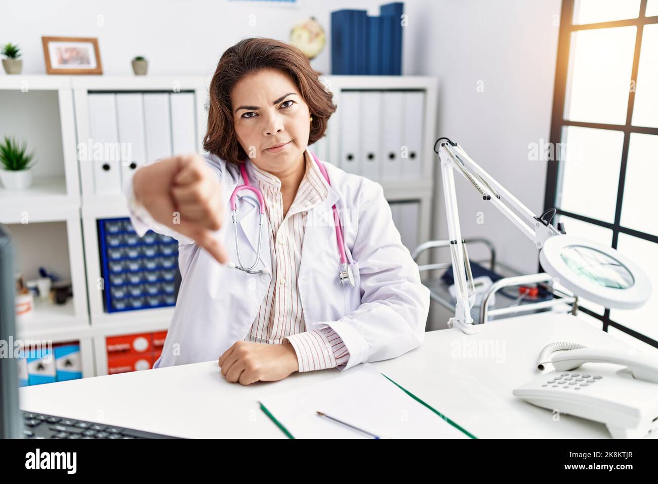 Middle age hispanic woman wearing doctor uniform and stethoscope at the ...