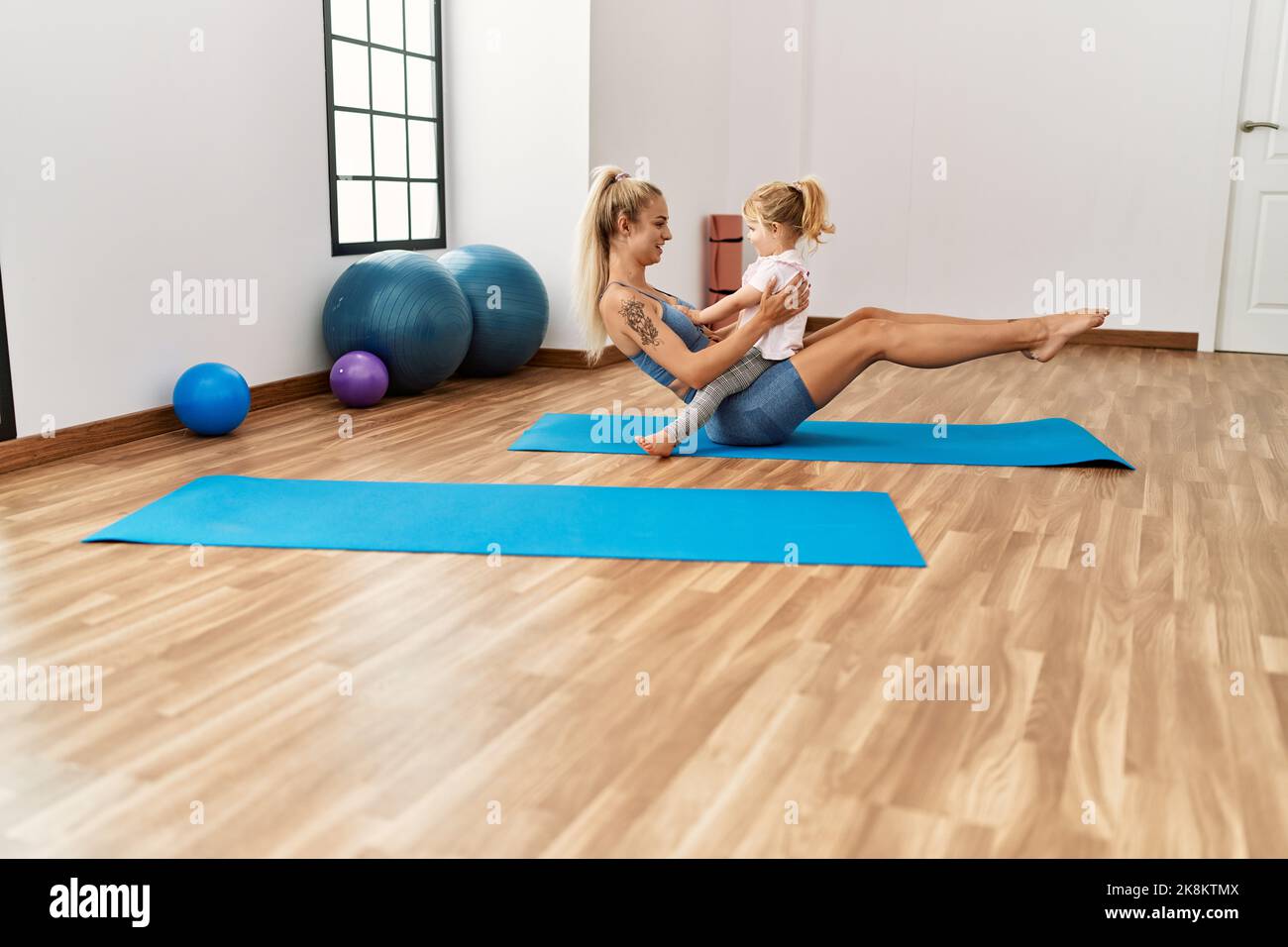 Mother and daughter smiling confident and hugging each other training ...