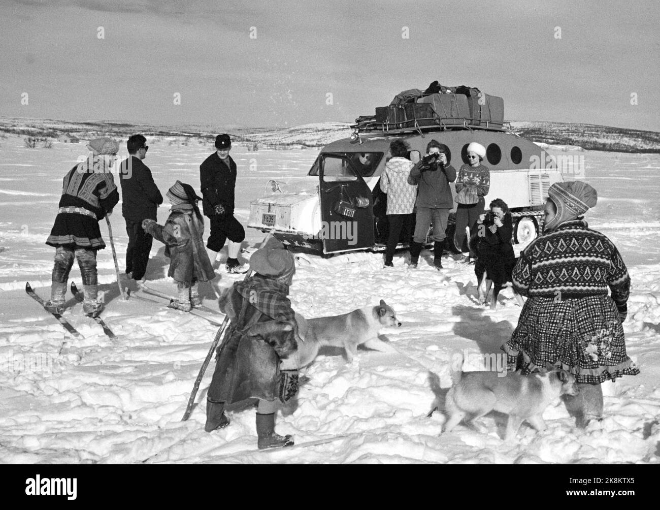 Finnmark 19650410 Caught by Finnmarksvidda -One of this year's travel news is winter trips to Finnmarksvidda. Also without the midnight sun, the region has a lot to offer the tourists: Meeting with Sami and reindeer, magnificent skiing and beautiful scenery. It is Bennett Reiseburå that arranges the trips north. The tickets at a price of NOK. 1295,- for 9 days trip, all incuded, was torn away. Here: Snowmobiles are on frozen rivers and unbroken roads. The tourists join and deliver mail to the same families. Photo: Aage Storløkken / Current / NTB Stock Photo