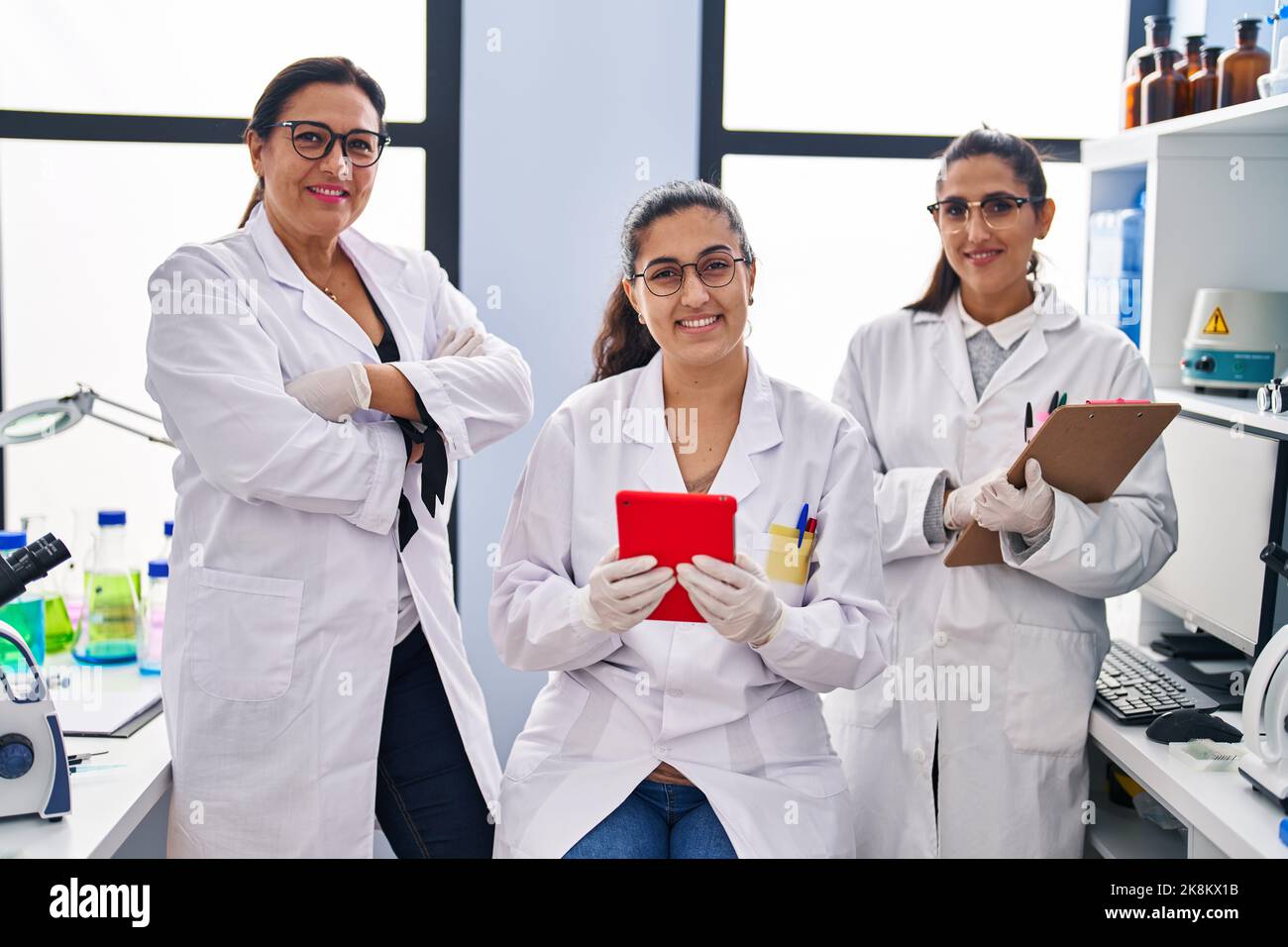 Three woman scientists using touchpad write on checklist at laboratory Stock Photo