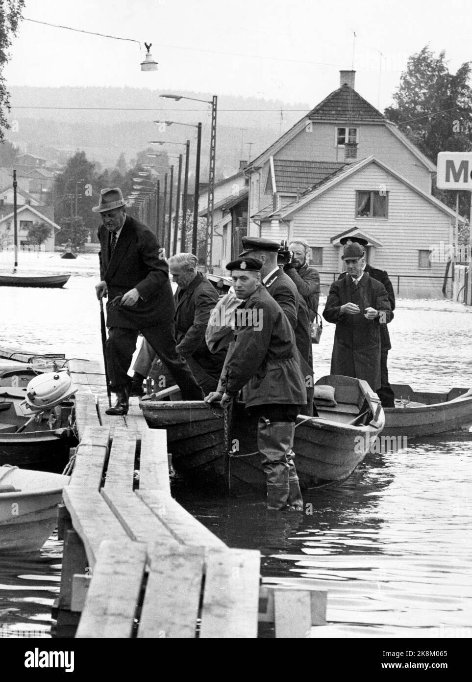 Lillestrøm 19670605 Flood put large parts of Lillestrøm underwater. More than 15,000 people were injured after the flood. Here King Olav visits the flood areas. King Olav goes ashore on one of the provisional pavements of wood set up over the water masses throughout the area. Photo: NTB / NTB Stock Photo
