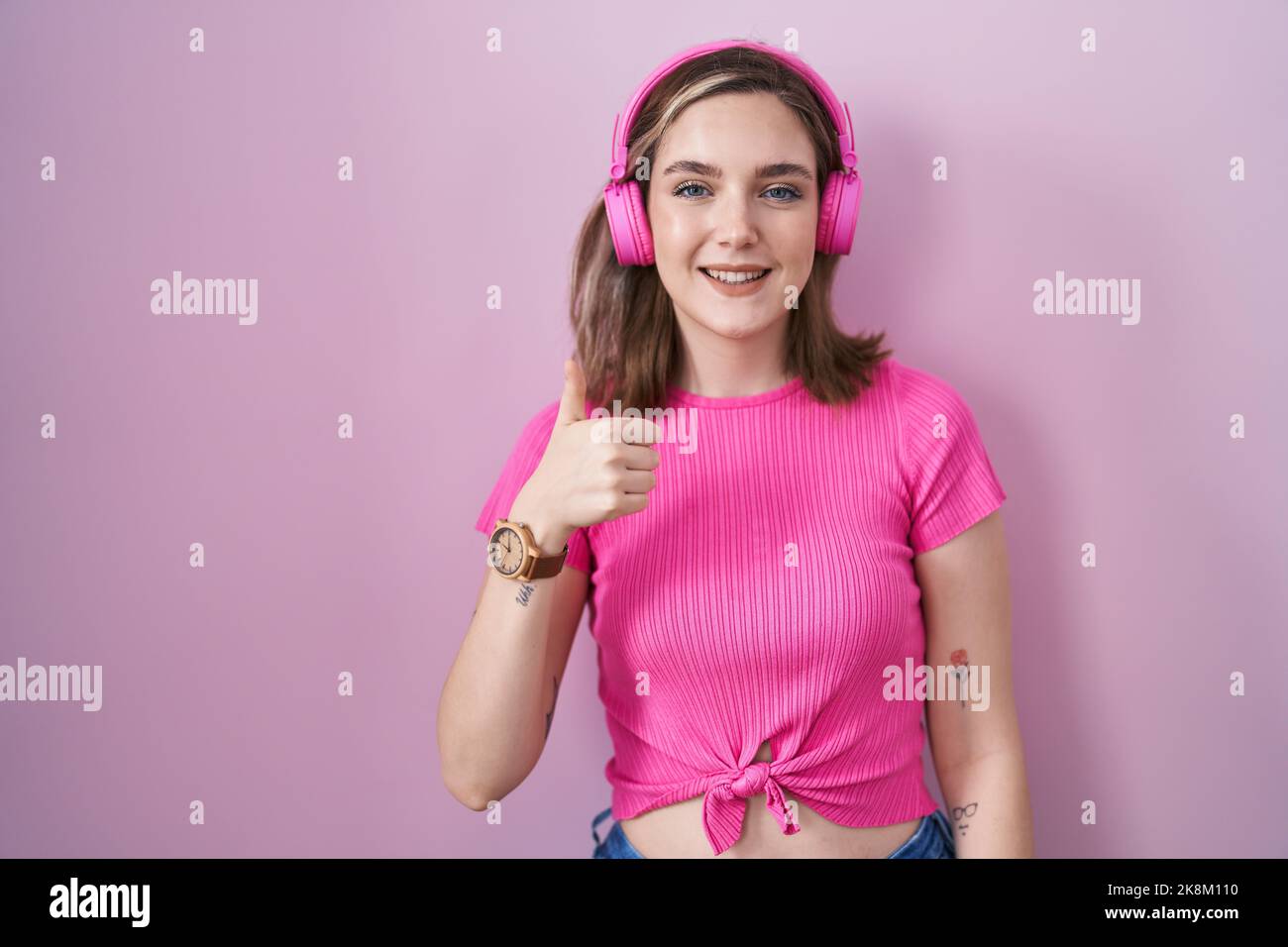 Blonde caucasian woman listening to music using headphones smiling ...