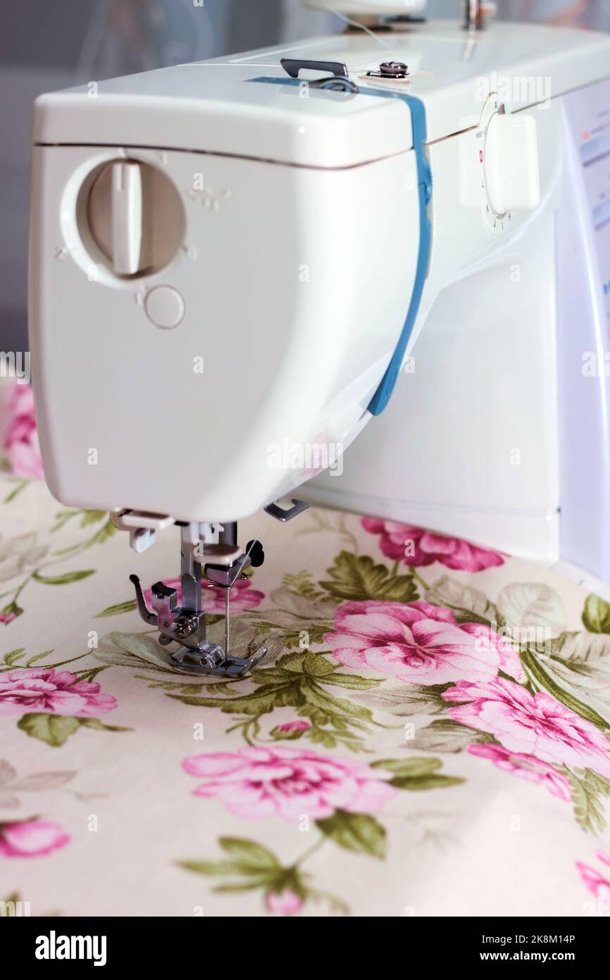 Modern sewing machine presser foot and colofrul cloth. Sewing process