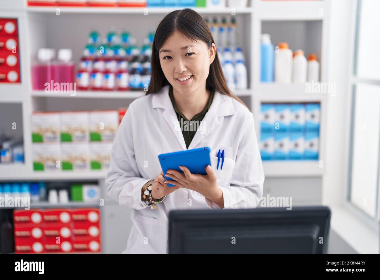 Chinese woman pharmacist using touchpad working at pharmacy Stock Photo ...