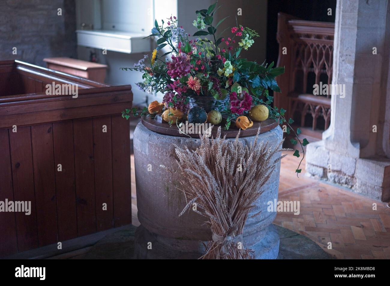Harvest festival decorations on a font in a parish church Stock Photo