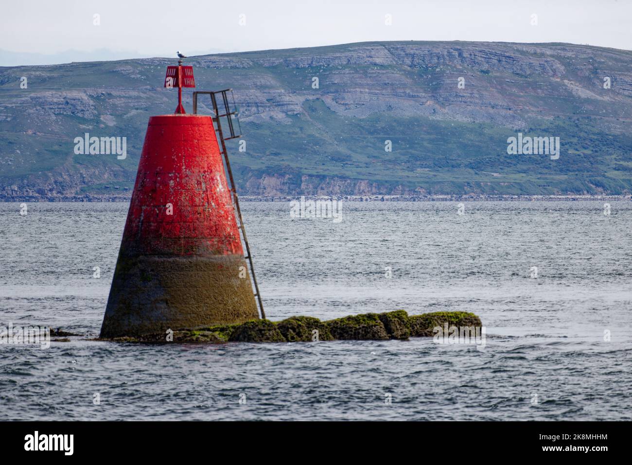 Carreg Edwen Rock buoy and the Great Orme aside the entrance to the Menai Straight viewed from Penmon Point, Anglesey, North Wales Stock Photo