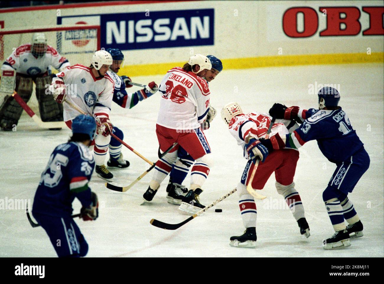 Lillehammer 19890331 B-World Cup in ice hockey in Norway. Action picture from Kampen Norway / Italy as Norway won 3-1. Norway's Tor Helge Eikeland (no. 26) and Kjell S. Foyn (22) are hindered sharply during the match. Photo: Inge Gjellesvik / NTB / NTB Stock Photo