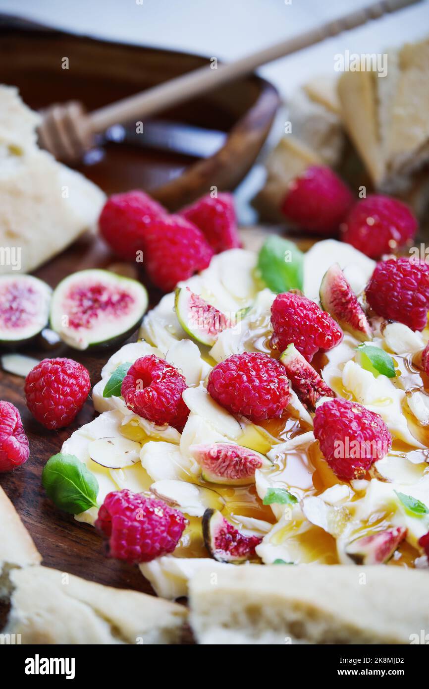 Butter board topped with fresh raspberries, figs, sliced almonds, basil