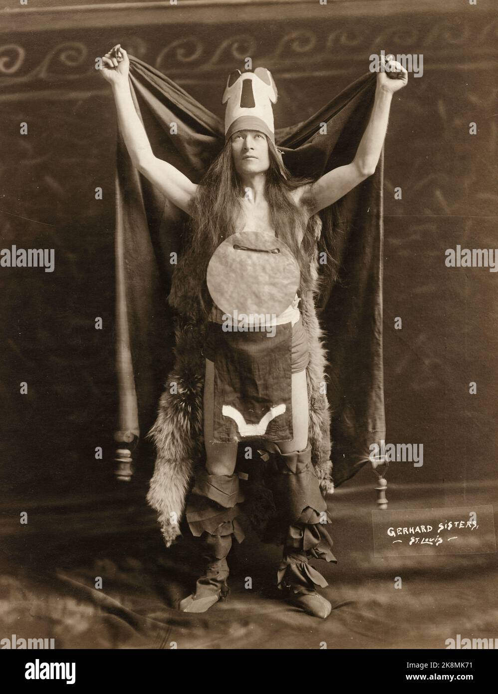 Gerhard Sisters - Mound Builder, High Priest - Pageant and Masque performer costumed as an American Indian standing with his arms raised - 1914 Stock Photo