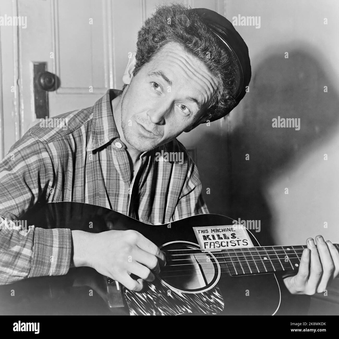 Woody Guthrie - Iconic photograph by Al Aumuller of the folk singer with guitar claiming 'This Machine Kills Fascists' - 1943 Stock Photo