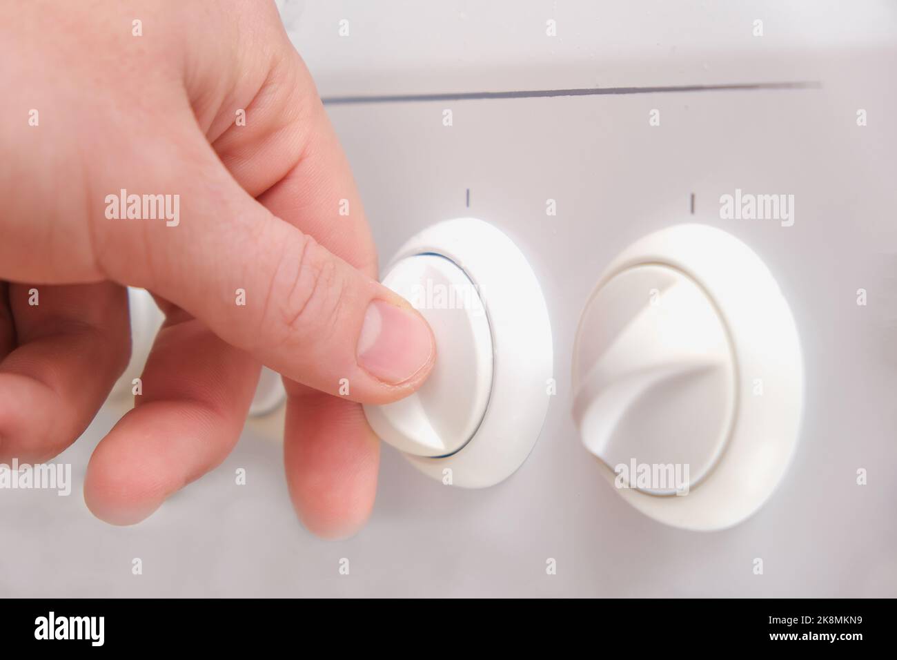 A man turns the handle of a white gas stove. White gas stove. A man lights a fire on gas stove