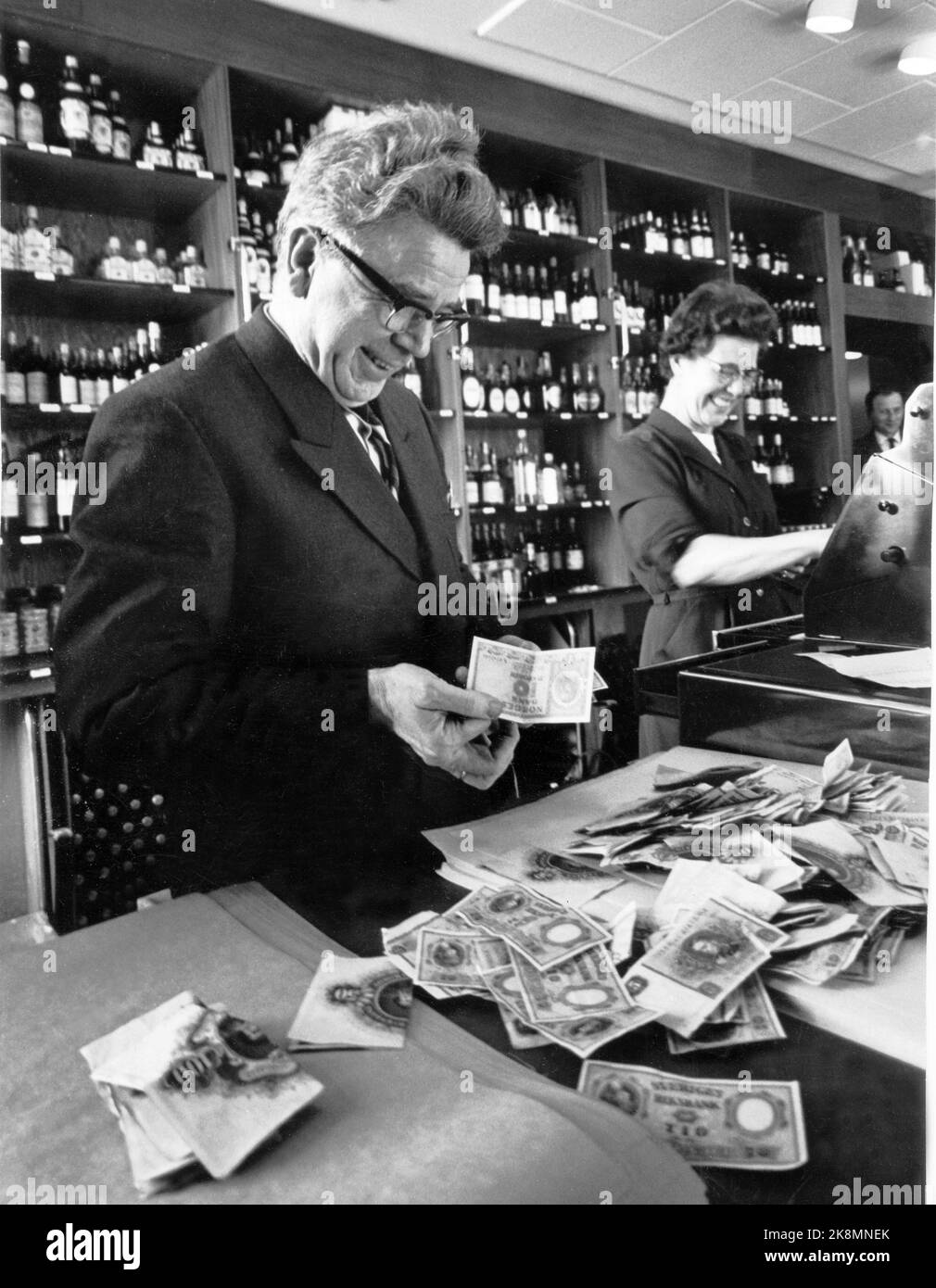 Sarpsborg 19630407: As a result of pole strikes in Sweden, the Swedes were in the Norwegian Polkø for once to secure precious drops for the Easter celebration. Polet in Sarpsborg had record sales, and most paid with Swedish kroner. At the Kassa settlement, the clerk Sverre Larsen found a single Norwegian tikrowner note among all the Swedish banknotes. Money. Photo: Sverre A. Børretzen / Current / NTB Stock Photo