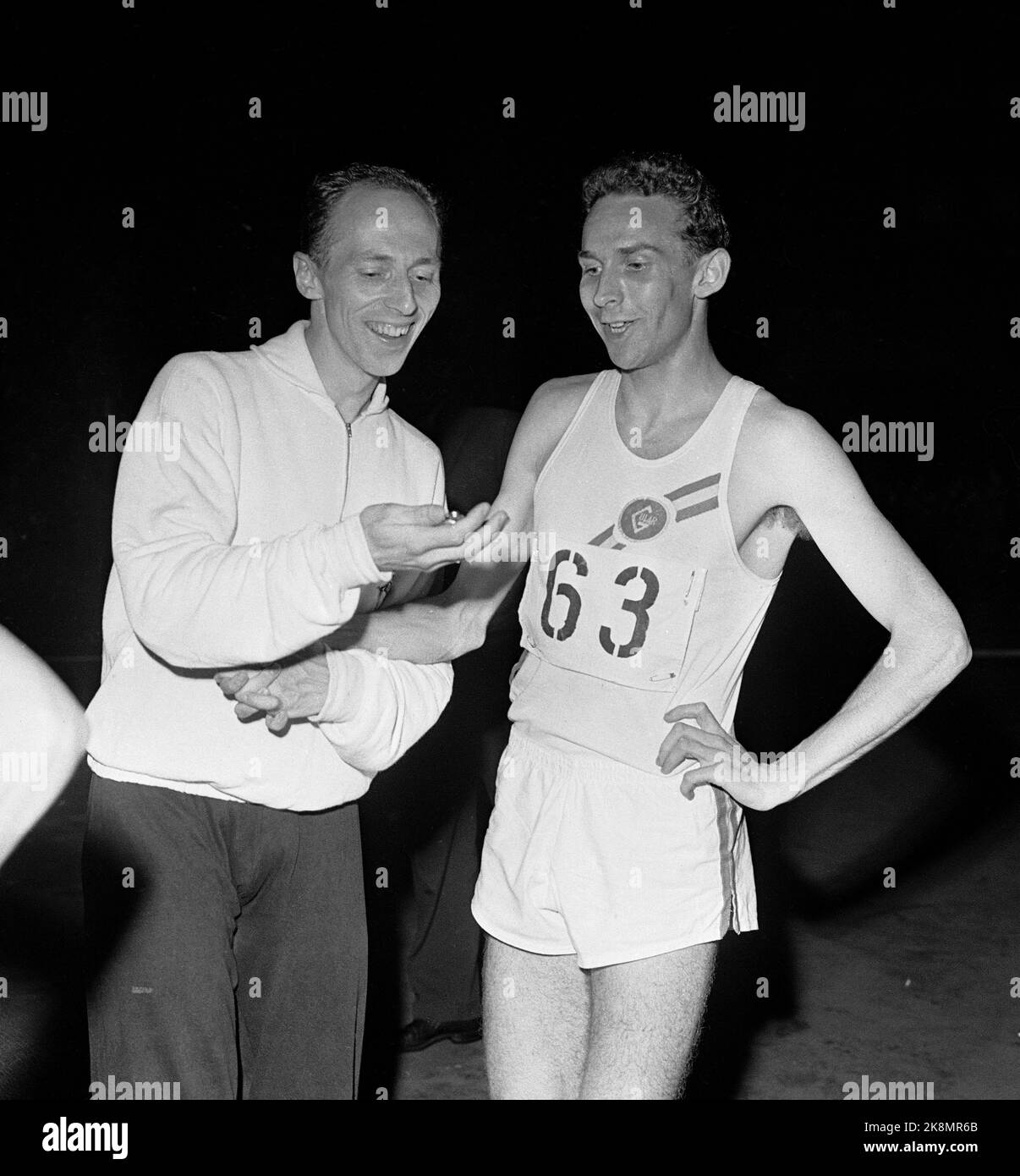 Oslo 19580905 International Athletics Conference at Bislett offered one of the fastest 1500 meters of the time. Arne Hamarsland from Gular ran into the world elite with a race of 3.39.8 which was the new Norwegian and Nordic record. He became No. 3 in the distance after Australian Elliot, who set a world record, and Hallberg from New Zealand. Here congratulates the runner king Audun Boysen (TV) Arne Hamarsland, and shows him the new record on a stopwatch. Photo: NTB / NTB Stock Photo