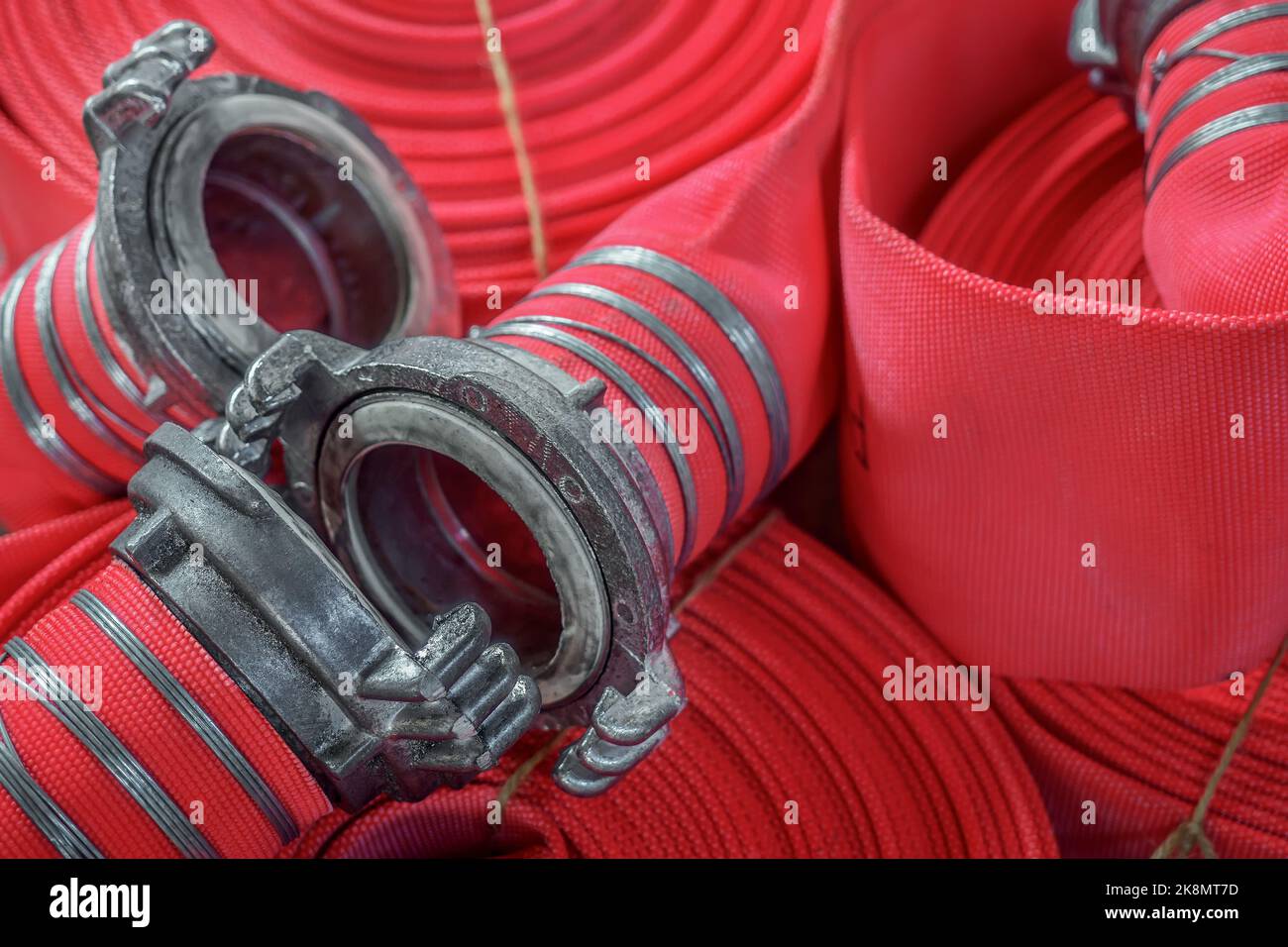 View of many twisted red fire hoses close-up in full screen. New fire