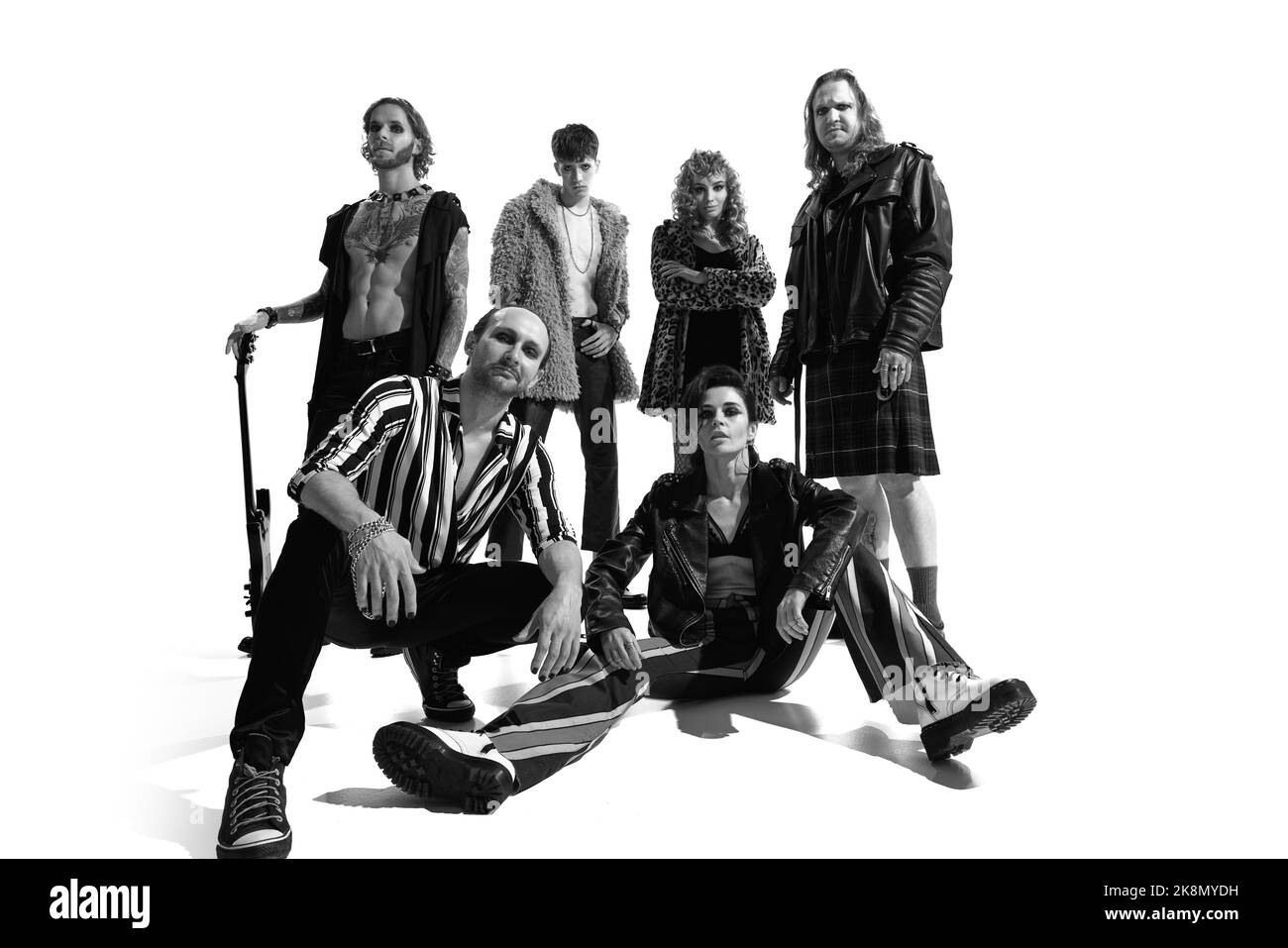 Group of stylish expressive people, man and woman, rock music performers posing over white background. Black and white photography Stock Photo