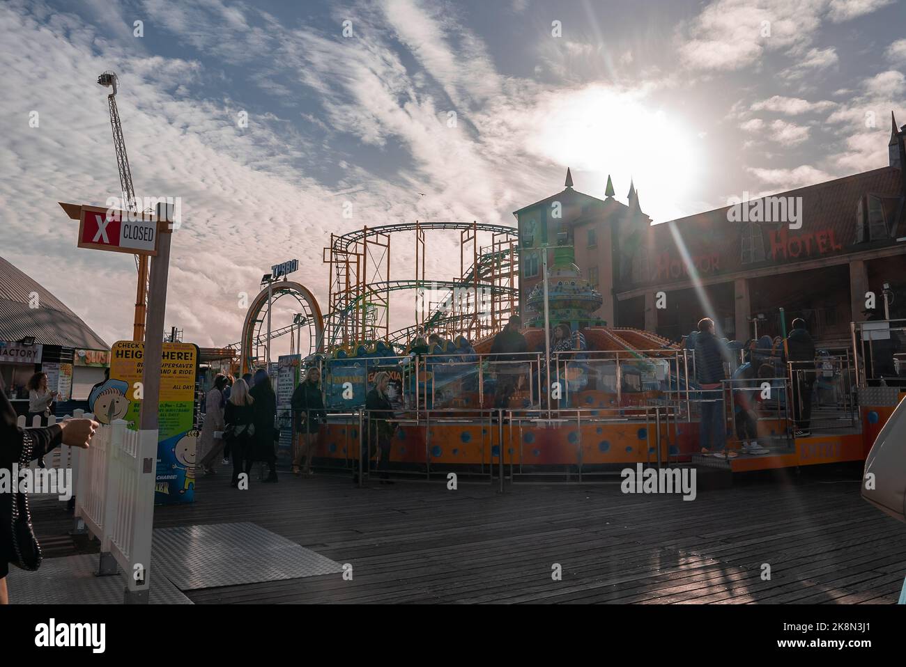 Holiday makers on roller coasters and rides at the amusement park on ...