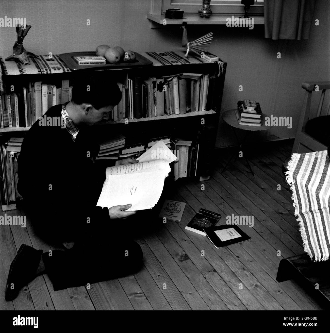 Oslo. Oslo 12041959. At the home of the author Helge Hagerup. Here he goes through old manuscripts. On the floor are the books; 'A journey in time', 'a stab in the heart' and 'We five on the second floor' All written by Helge Hagerup. Photo: Aage Storløkken / Current / NTB Stock Photo