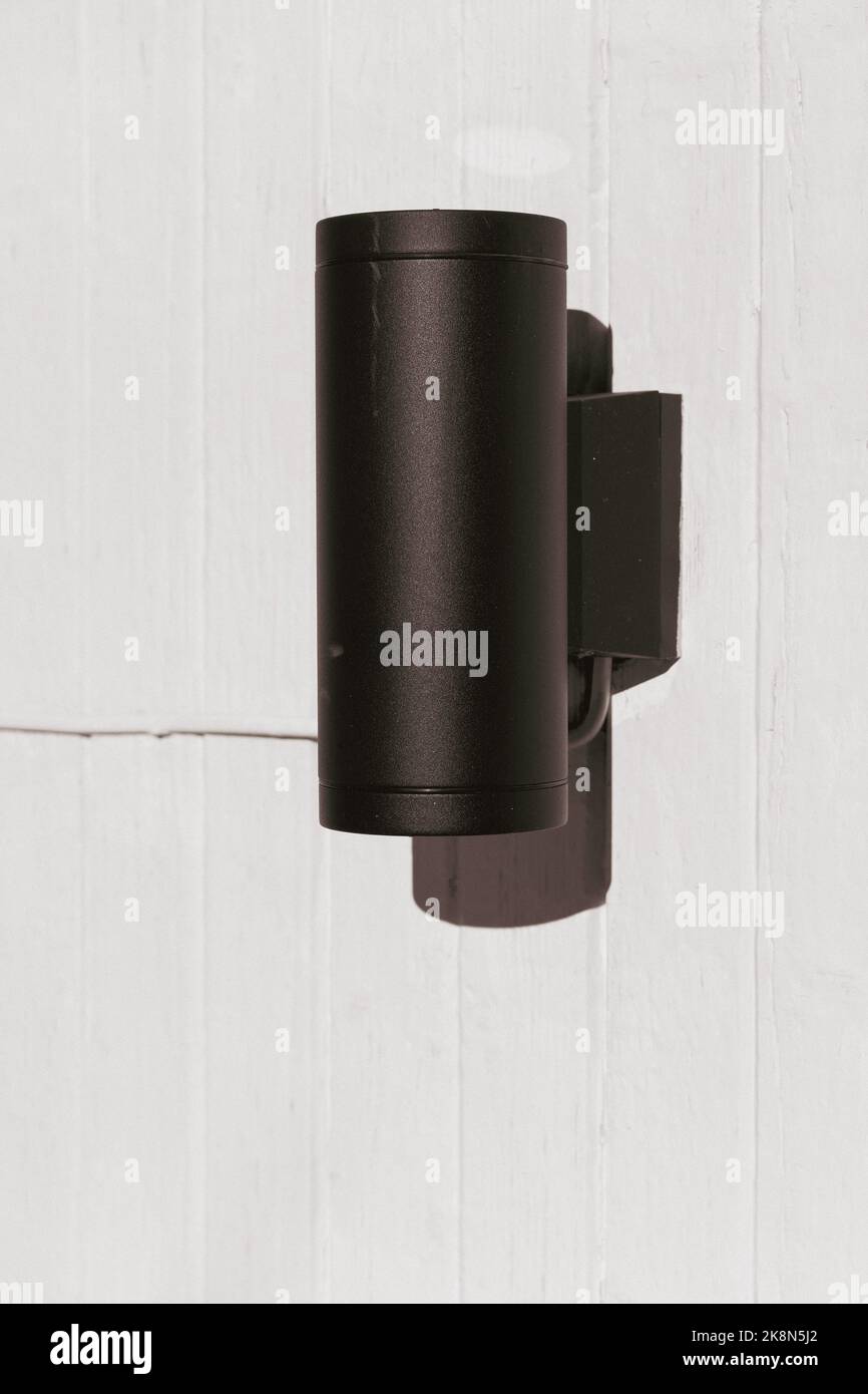 black outdoor lamp with shielded light bulb Stock Photo Alamy
