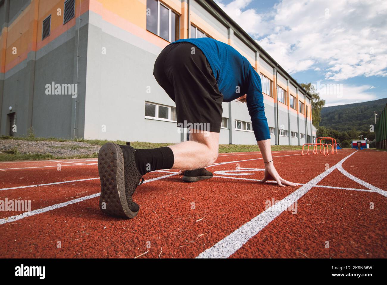 Detail of the body position of a professional athlete at the start of a 100m sprint. Outdoor