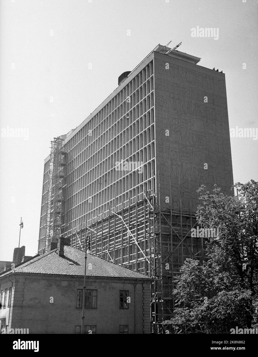 Oslo 19580724. The new government building under construction, June 1958. The artwork on the facade are sandblasted reliefs with symbolic figures, designed by architect Erling Viksjø, who collaborated with the artist Carl Nesjar on the technical execution. Old buildings in the area have not yet been demolished. 17352 Photo: Jan Nordby/NTB Stock Photo