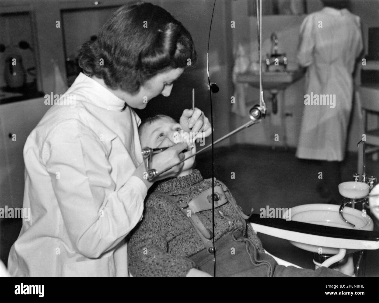 Oslo 1941: Oslo Municipal folk kan care in Møllergata 24. Little boy in the dental chair. Female dentist at work. Photo: NTB Stock Photo