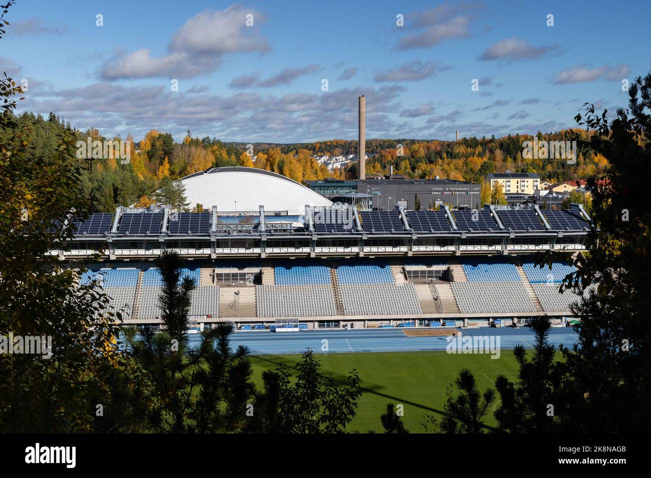 Lahti, Finland. October 9, 2022. Lahti Stadium stands seen from between the trees in autumn Stock Photo