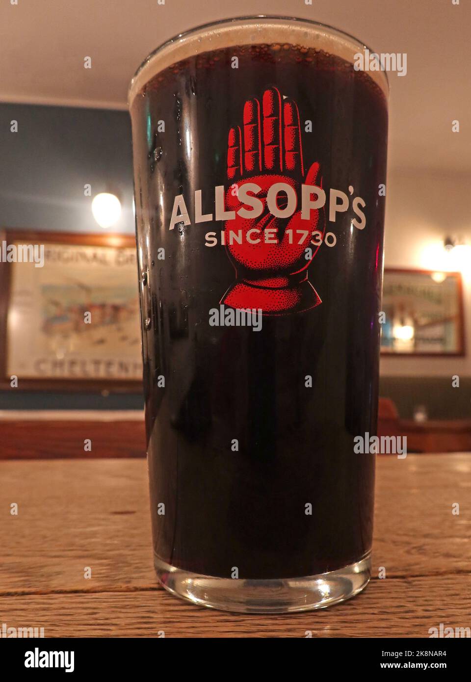 Pint glass in a bar, Allsopps Ales Since 1730, dark beer or stout, red hand logo trademark. Brewery Stock Photo