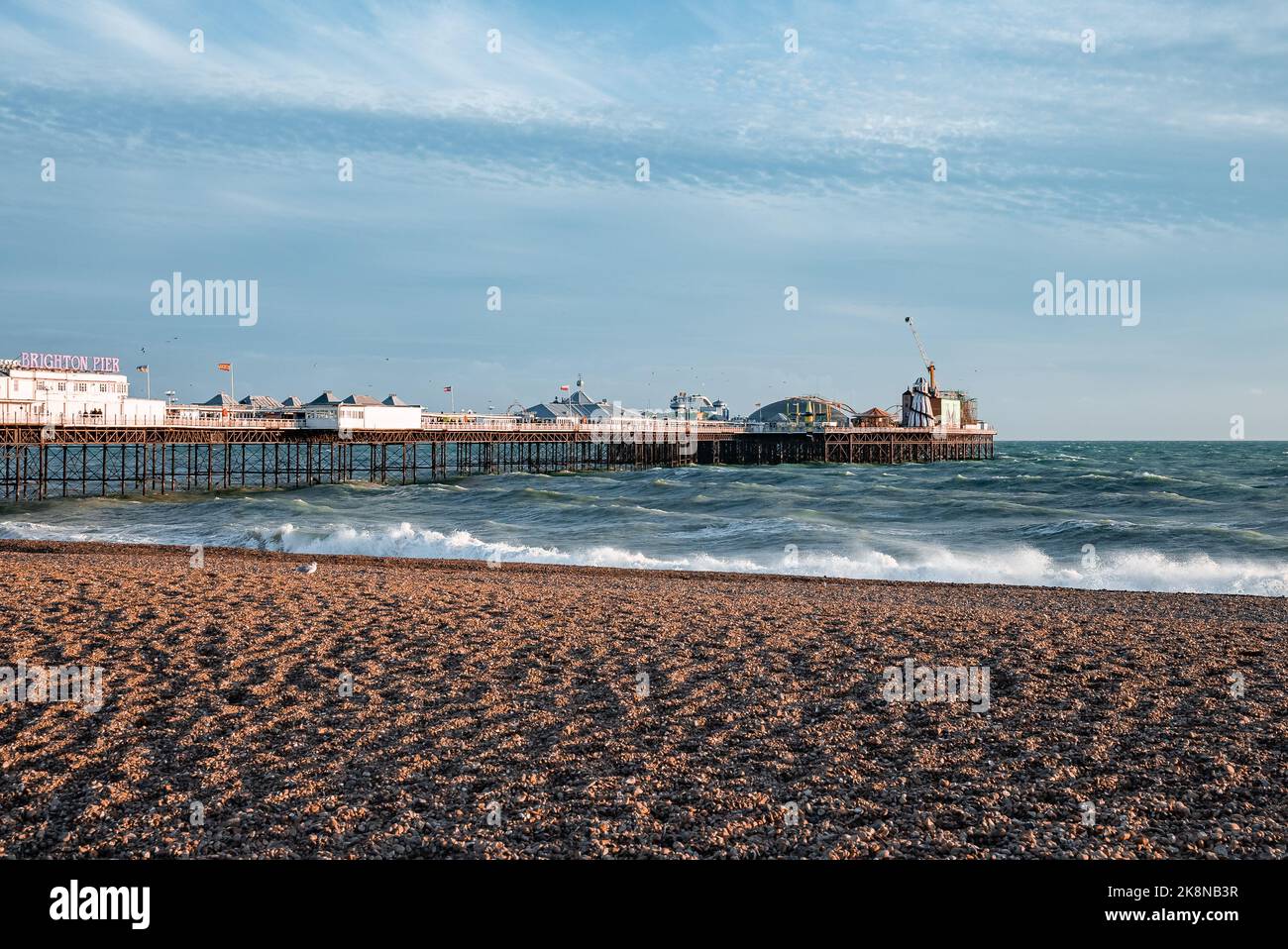People walking down the promenade near the beach in Brighton. Stock Photo