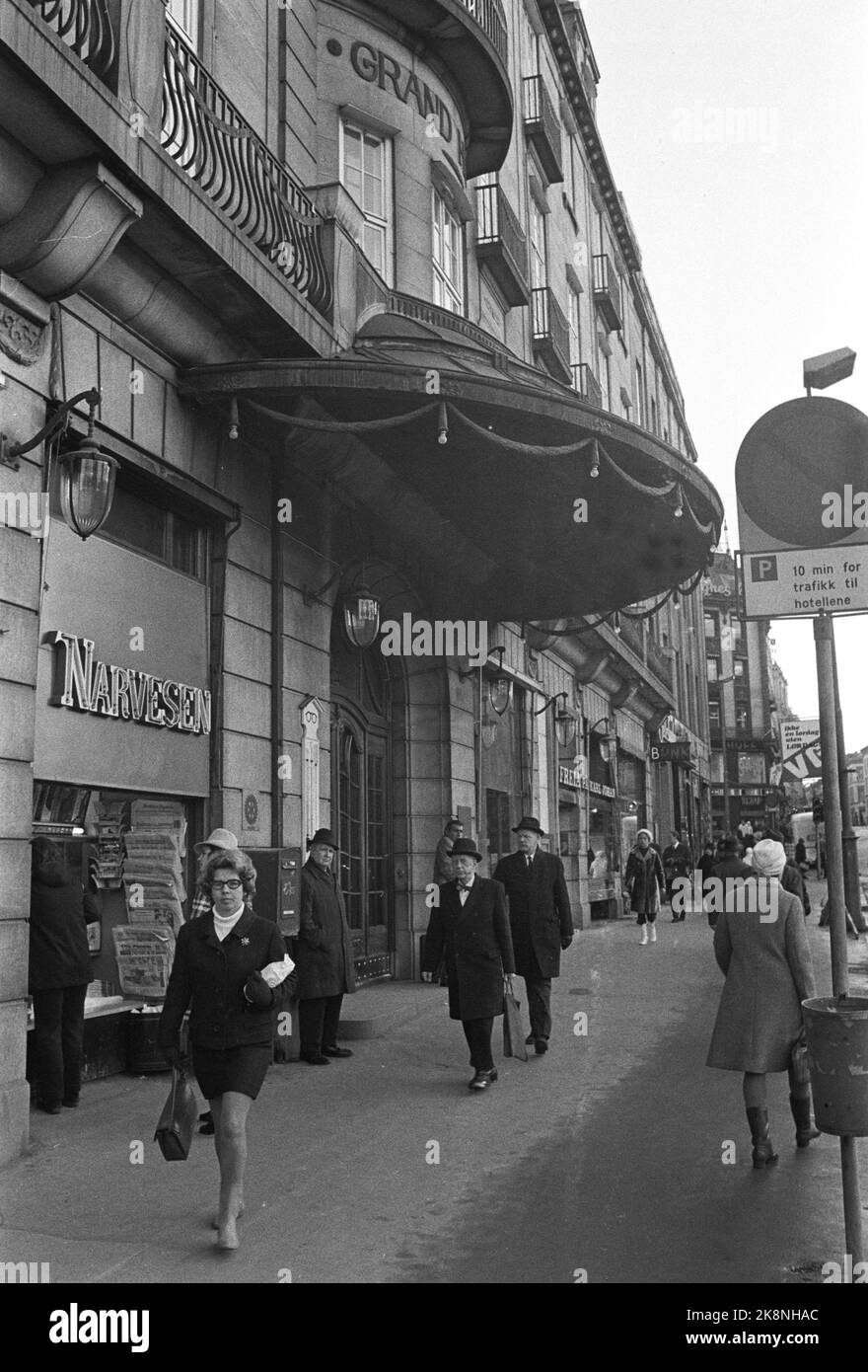 Oslo, 19710125. Exterior motif of the Grand Hotel. Karl Johans gate 31. The entrance area with the characteristic canopy. Narvesen kiosk t.v. For the entrance area, traffic signs, men with hat and coat and woman in mini skirts. Photo: Henrik Laurvik Stock Photo