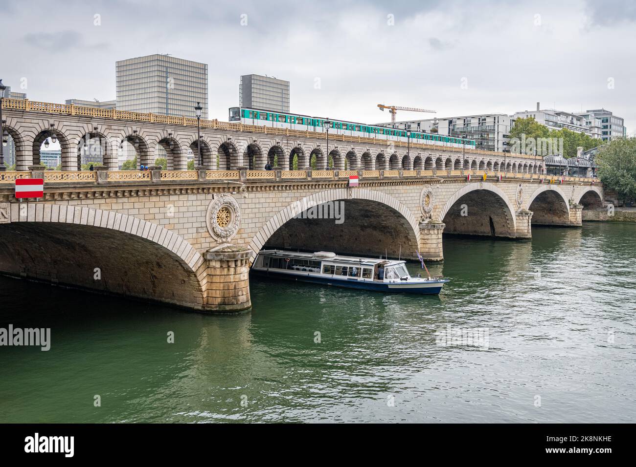 Pont de Bercy combined Road and Rail Bridge across River Seine with a train crossing and a boat emerging from under the bridge, Paris, France Stock Photo