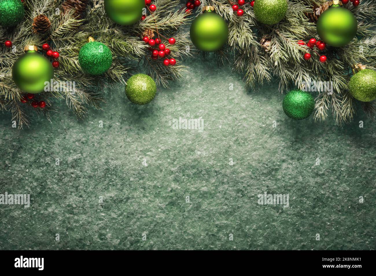 Christmas background in green, with textured copy-space and an arch-shaped border composed of fir branches, baubles and holly Stock Photo