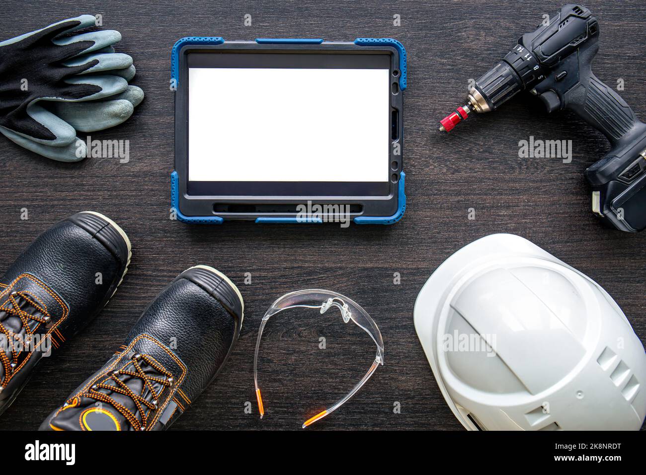 Digital tablet with layout and worker clothes, top view. Stock Photo