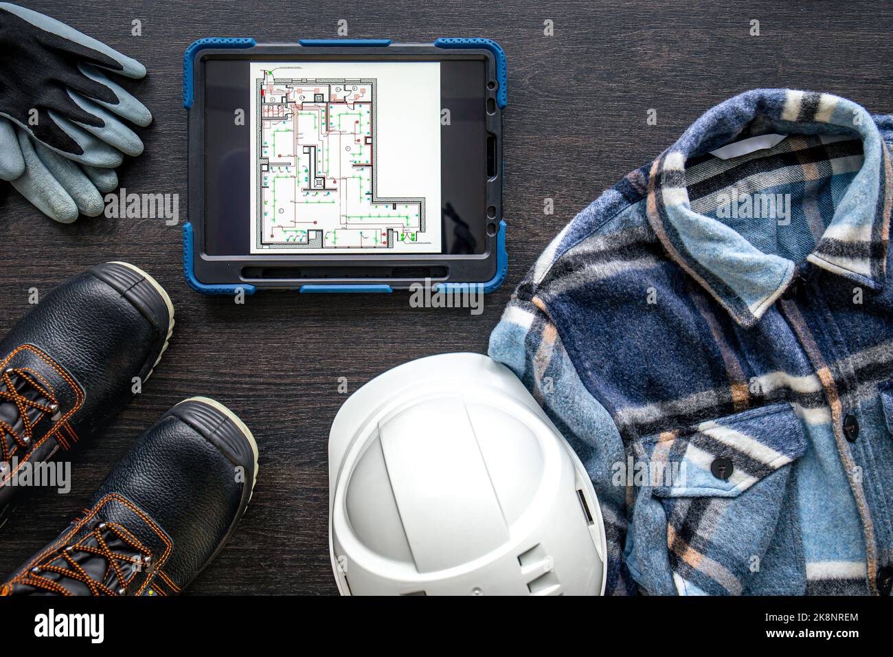 Digital tablet with layout and worker clothes, top view. Stock Photo