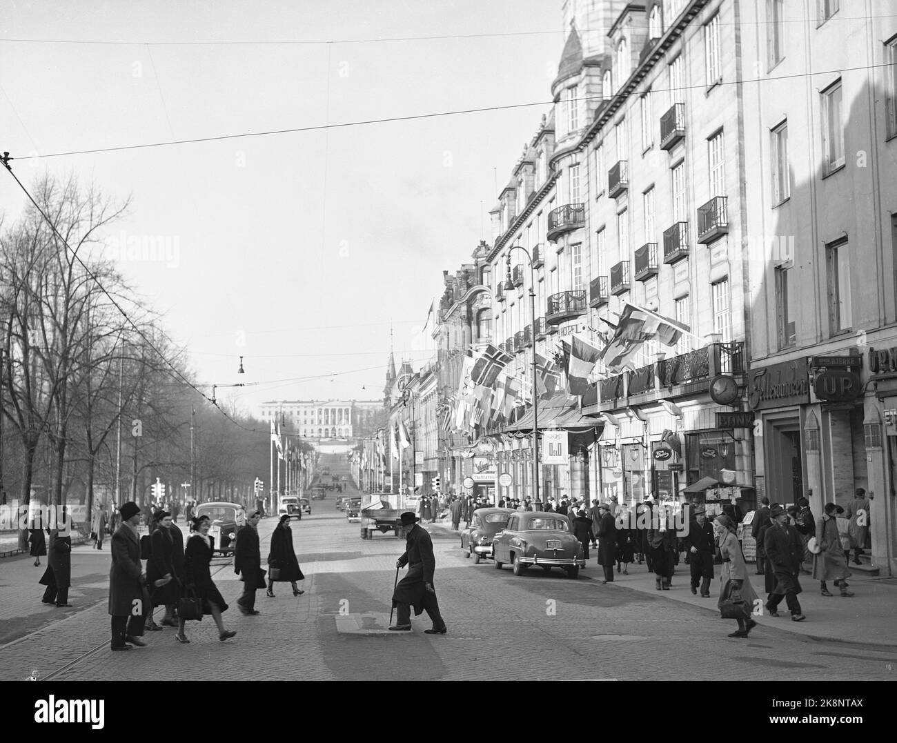 Oslo 19520211. Winter Olympics 1952. Olympic and Norwegian flags hang over the entrance at the Grand Hotel (t.h.). Karl Johans gate with the castle in the background. Photo: NTB Archive / NTB Stock Photo