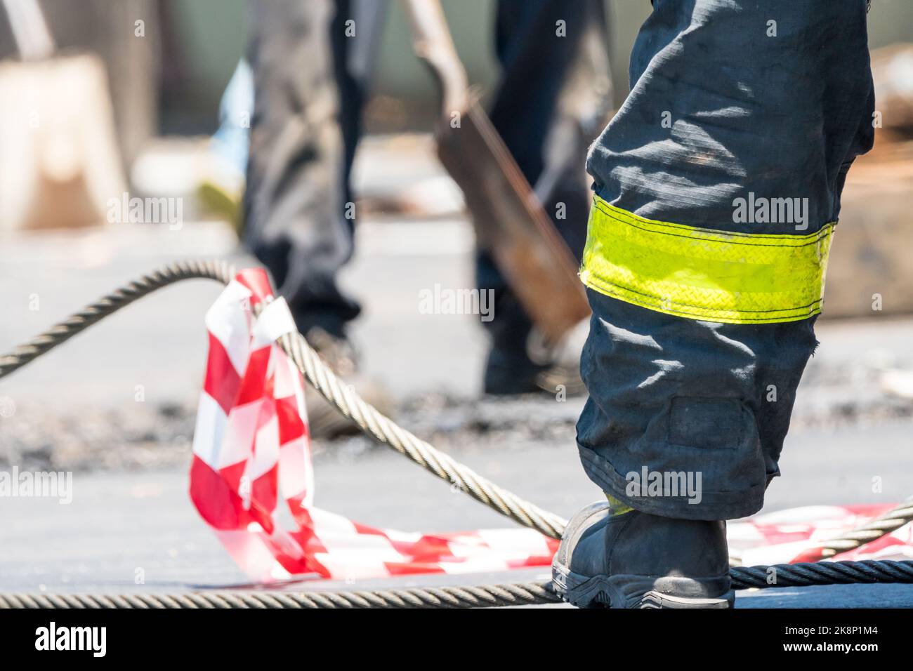 worker or emergency personnel wearing high vis or high visibility uniform or clothing and work boots at a road accident clean up operation Stock Photo